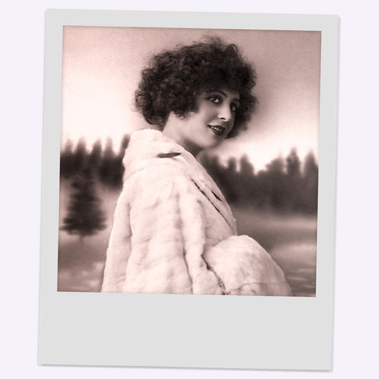Old photo of a woman with brown curly hair, taken from the 1920 era. 